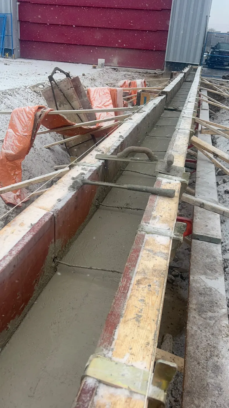 Concrete footing for retaining wall construction