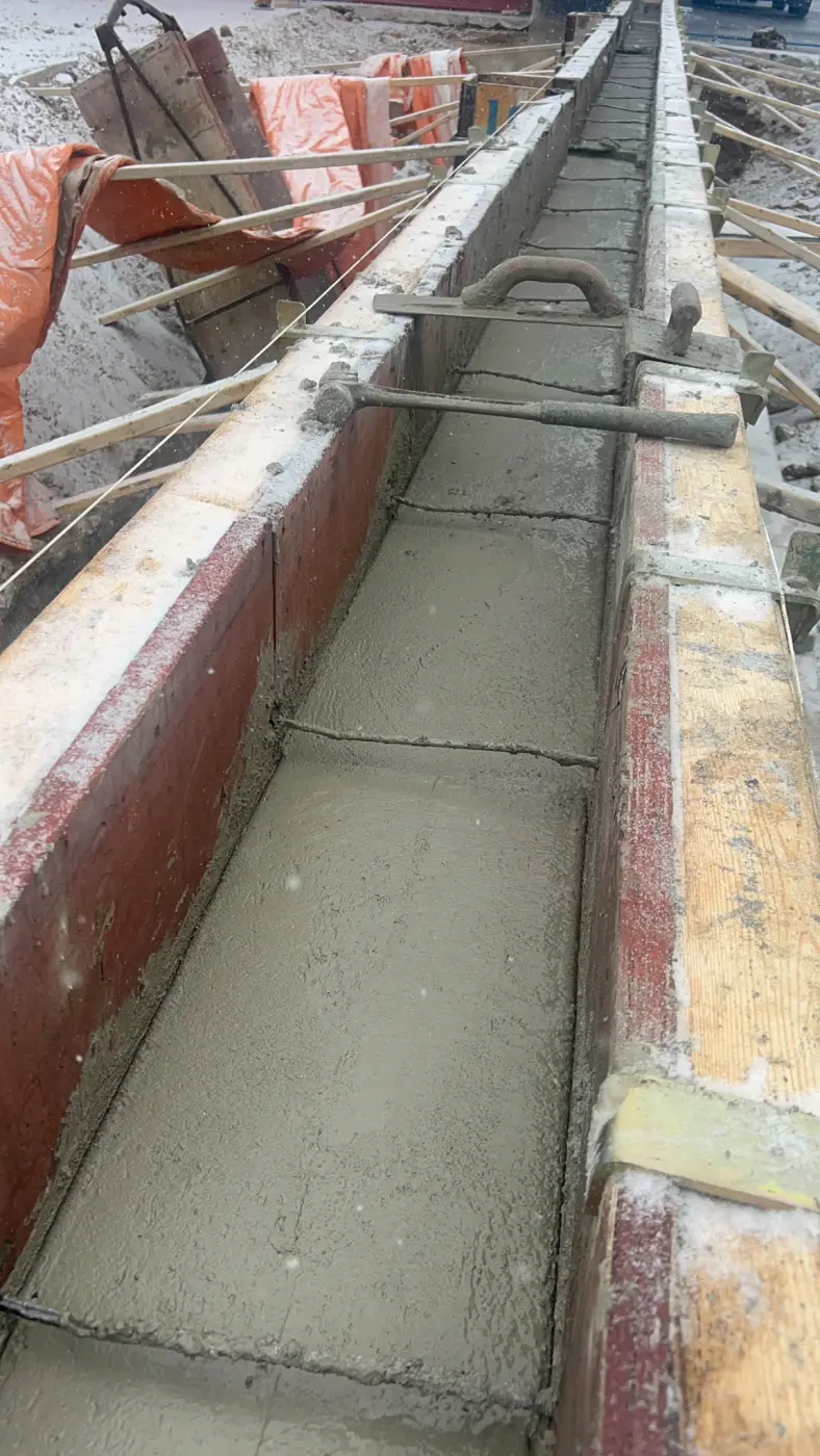 Concrete footing for retaining wall construction